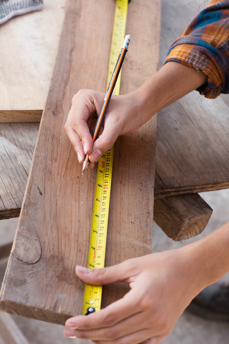 Woman Holding Yellow Ruler and Making Measures